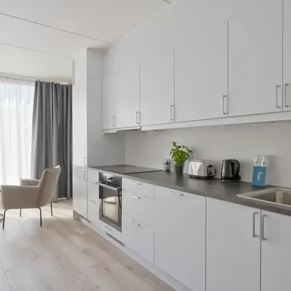 a kitchen with white cabinets and a wood floor
