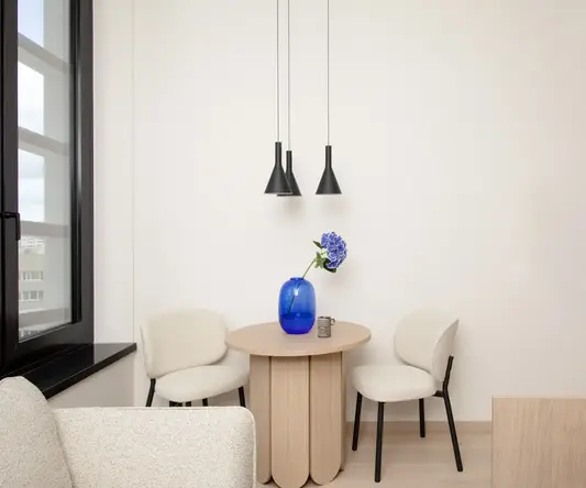 a table with chairs and a vase of flowers