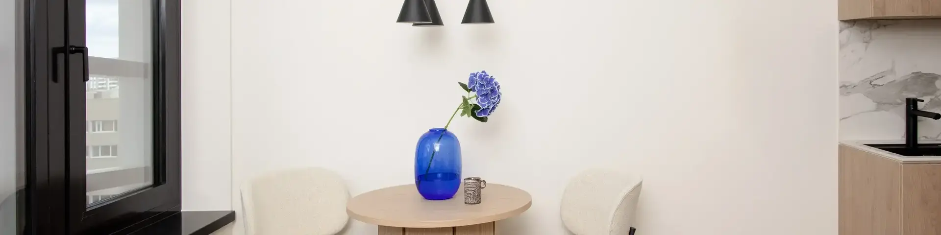 a table with chairs and a vase of flowers