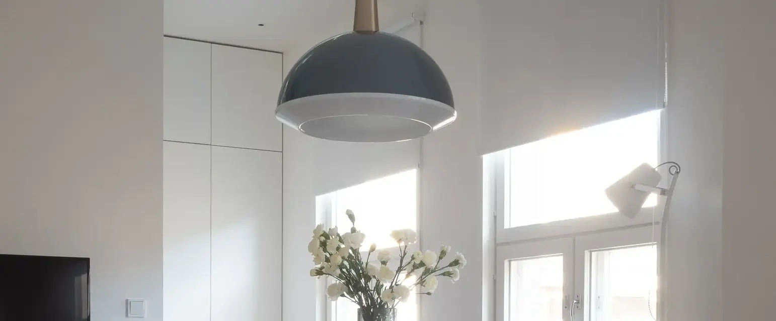 a table with chairs and a vase of flowers in it