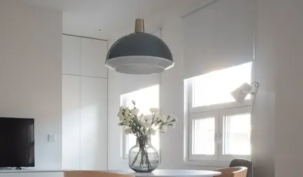 a table with chairs and a vase of flowers in it