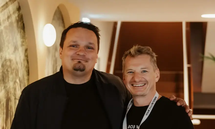 two men standing together smiling