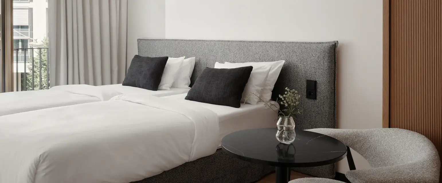 a bed with white sheets and black pillows in a room