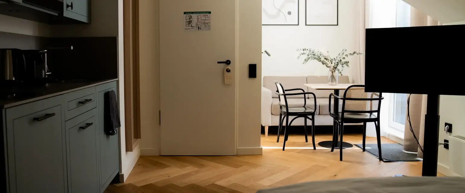 a room with a door and a table and chairs