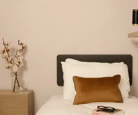 a bed with a brown pillow and a book on it