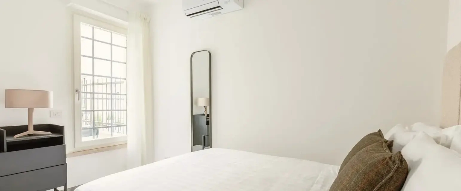 a bed with a pillow and a mirror in a room