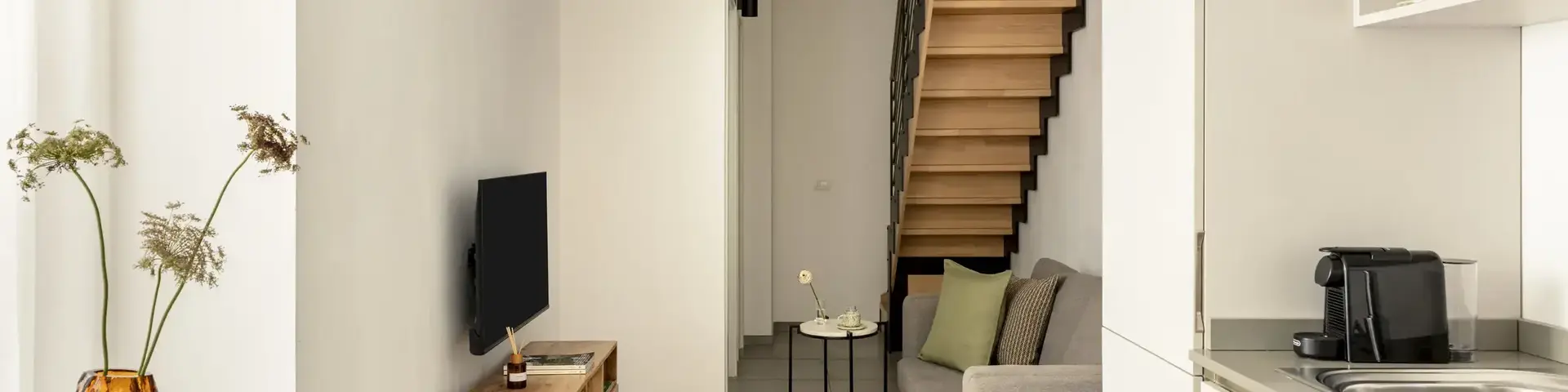 a living room with a staircase and a couch