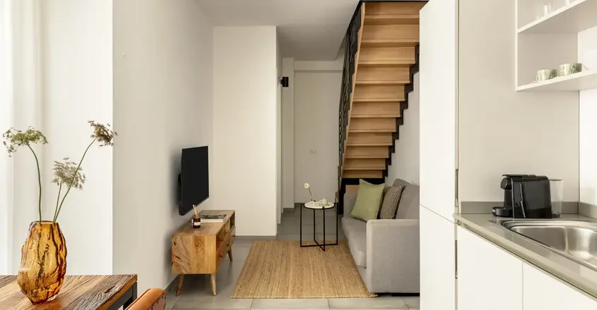 a living room with a staircase and a couch
