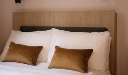 a bed with pillows and a light fixture