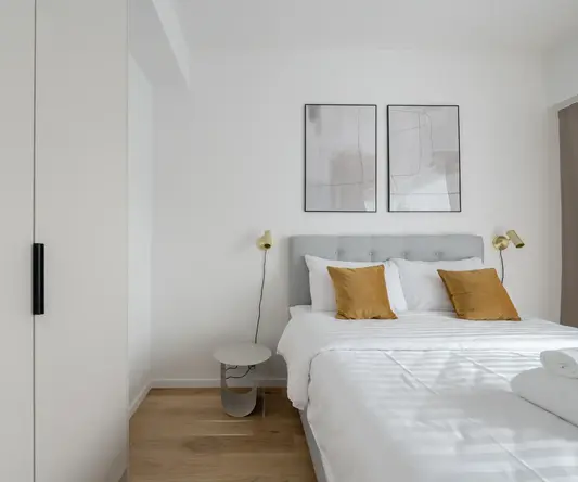 a bed with pillows and a lamp