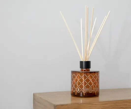 a brown glass bottle with sticks in it