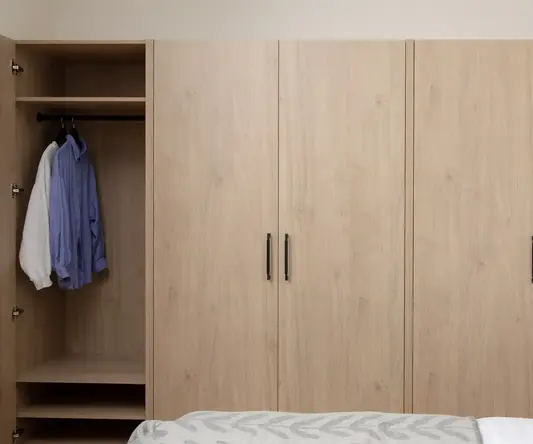 a wooden closet with black handles