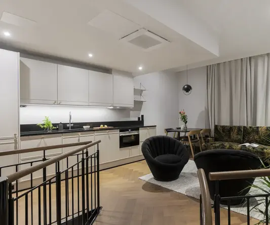 a room with a couch and chairs