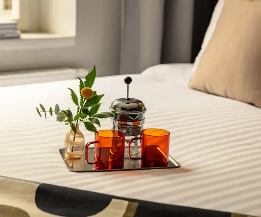 a tray with cups and a vase of flowers on it