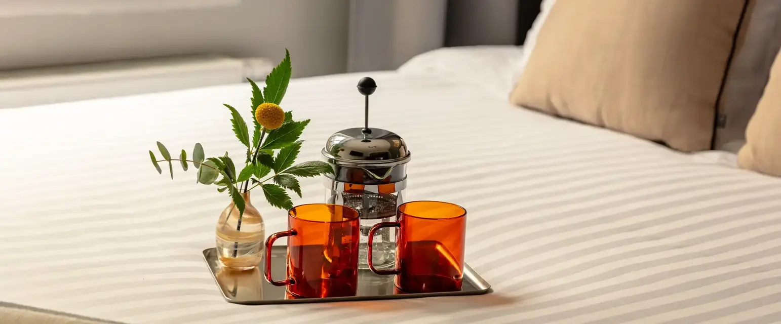 a tray with cups and a vase of flowers on it