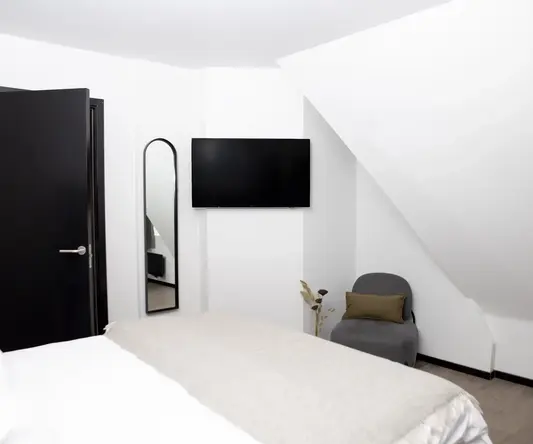 a bedroom with a tv on the wall