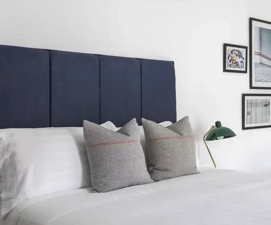 a bed with pillows and a lamp