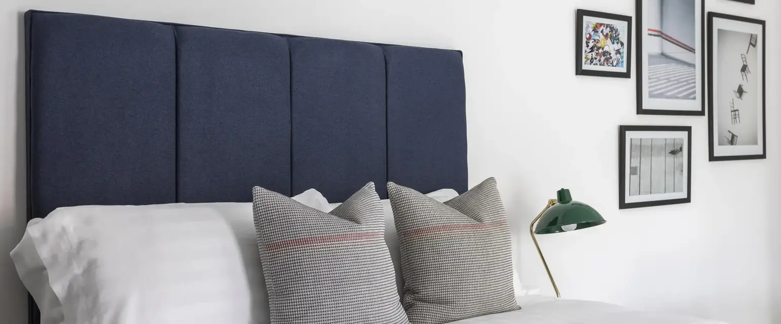 a bed with pillows and a lamp