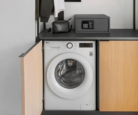 a laundry room with a washing machine and a black box
