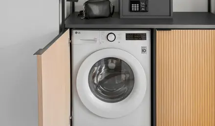 a laundry room with a washing machine and a black box