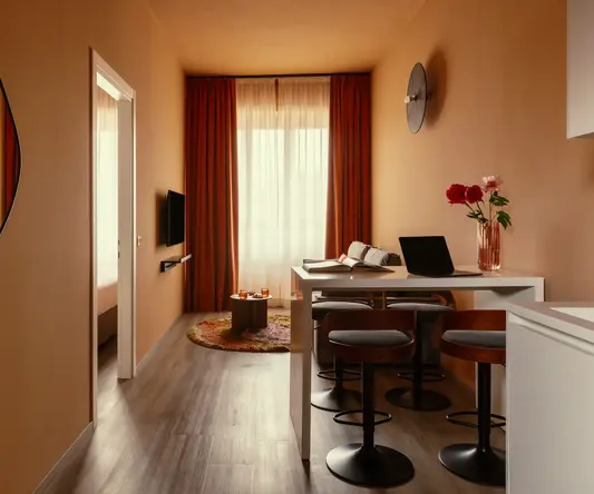 a room with a table and chairs and a laptop