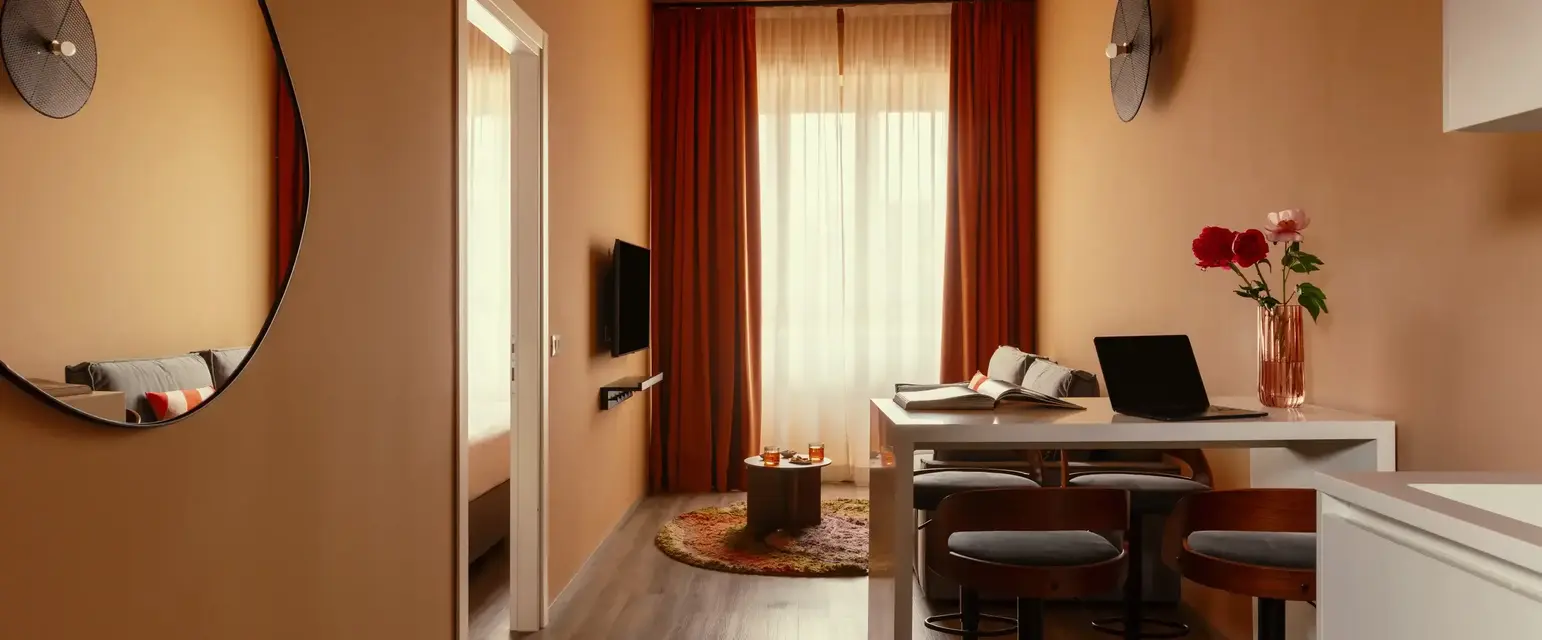 a room with a table and chairs and a laptop