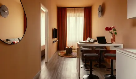 a room with a table and chairs and a laptop