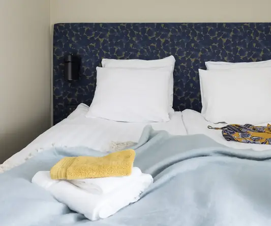 a bed with pillows and blankets