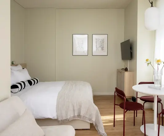 a bedroom with a table and chairs