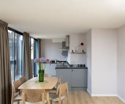 a dining table with chairs in a room with windows