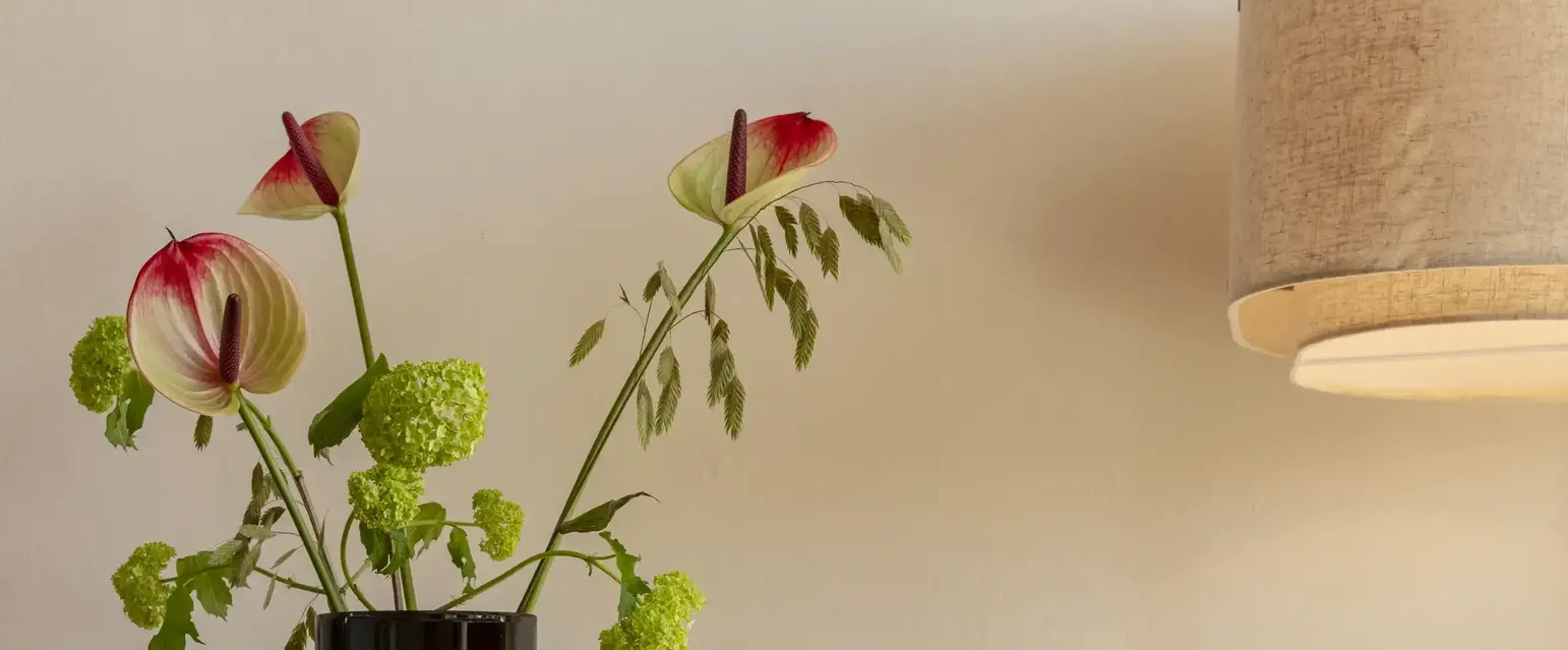 a vase with flowers and sunglasses on a table
