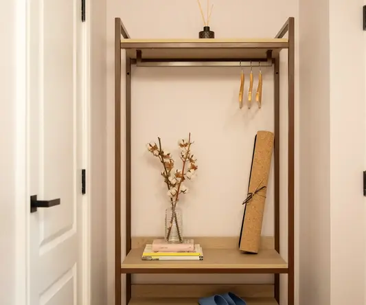 a shelf with books and a vase of flowers on it