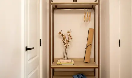 a shelf with books and a vase of flowers on it