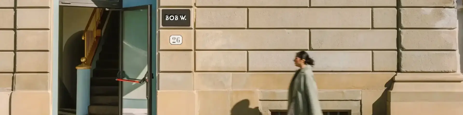 a woman walking with luggage in front of a building
