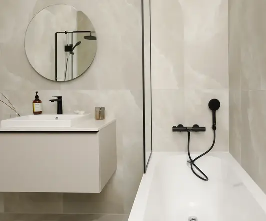 a bathroom with a round mirror and a bathtub