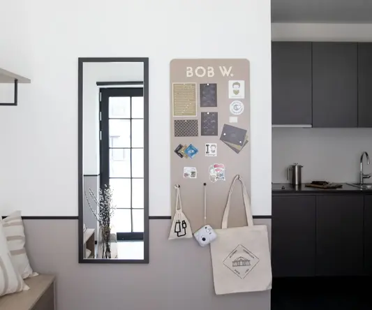 a wall with a mirror and a bulletin board