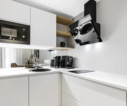 a kitchen with white cabinets and black appliances