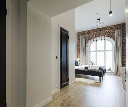 a hallway with a bed and a black door