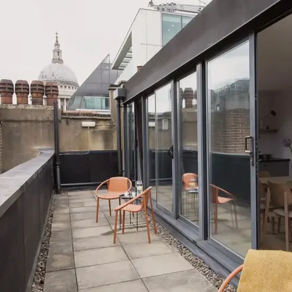 a patio with chairs and table on a rooftop