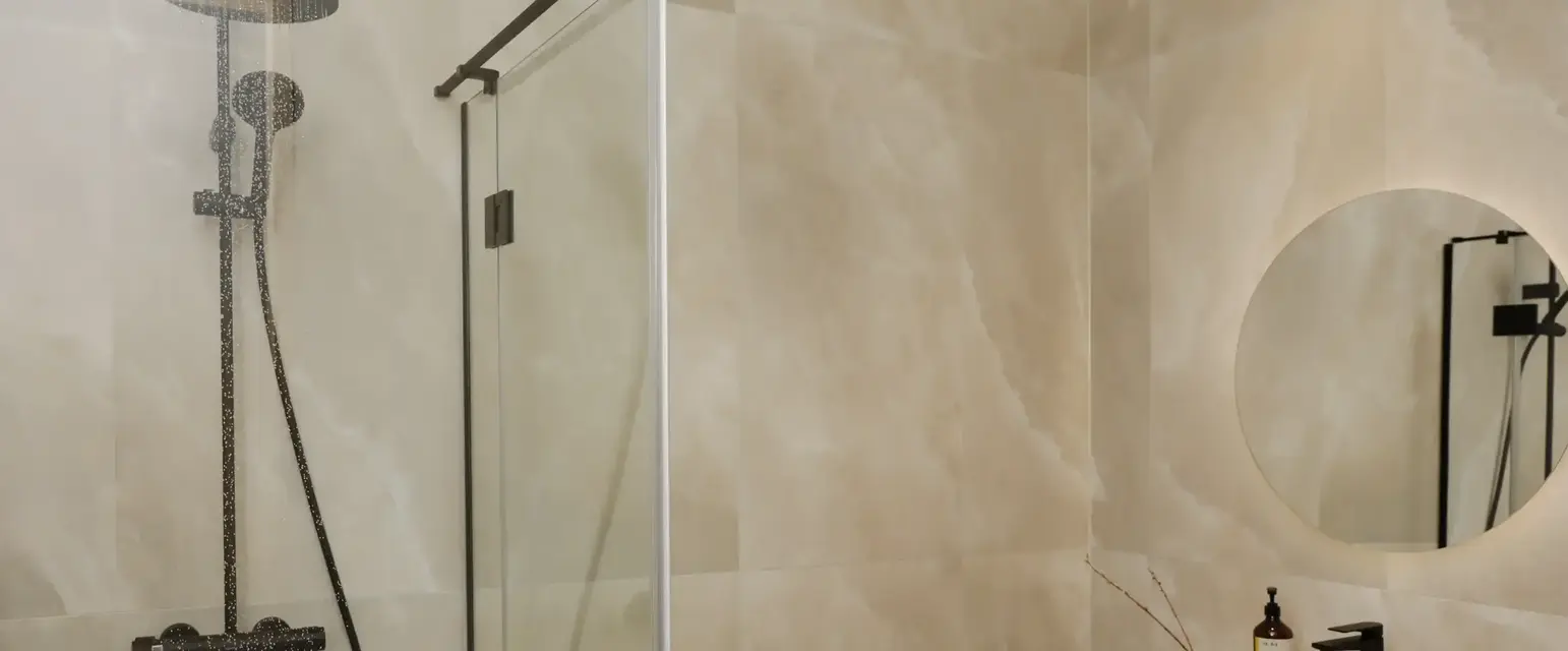 a shower with a glass door and a sink