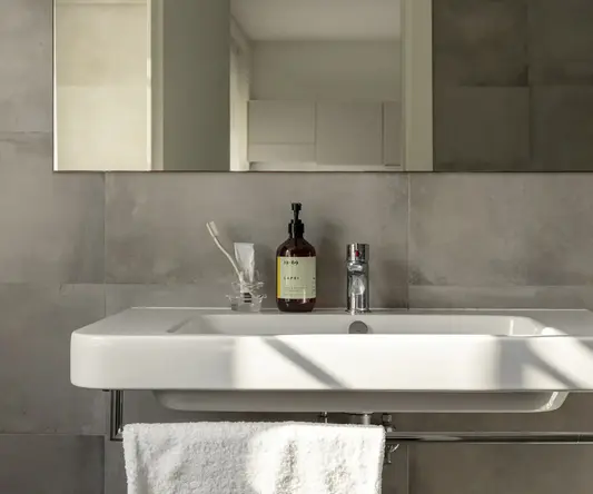 a bathroom sink with a bottle of soap and a towel