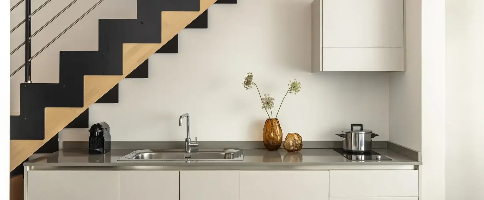 a kitchen with a sink and a pot on the counter