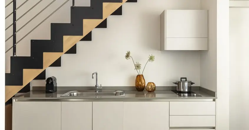 a kitchen with a sink and a pot on the counter