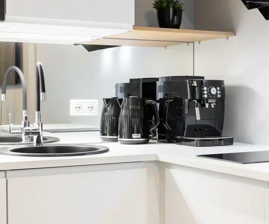 a kitchen counter with a sink and coffee maker