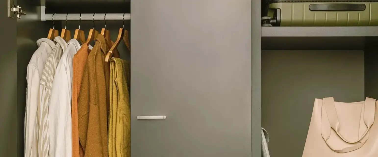 a closet with clothes and a suitcase