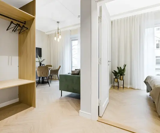 a room with a green couch and a wood floor