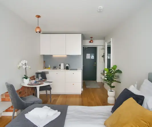 a room with a bed and a kitchen