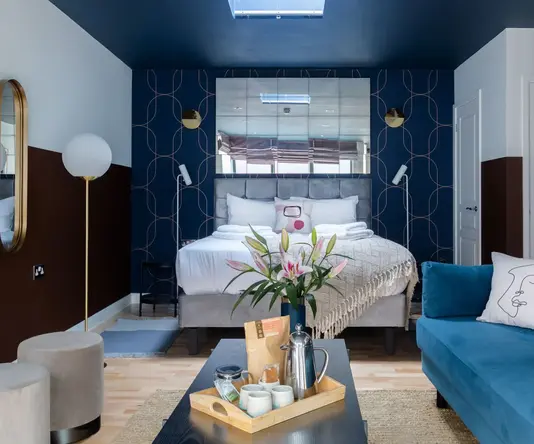 a room with a blue couch and a blue and white wall