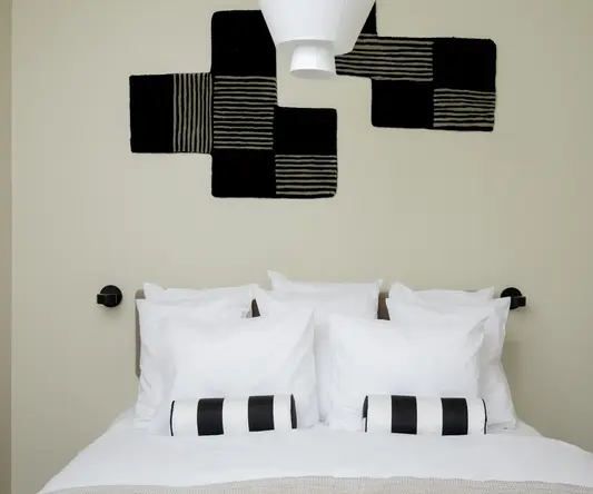 a bed with pillows and a lamp