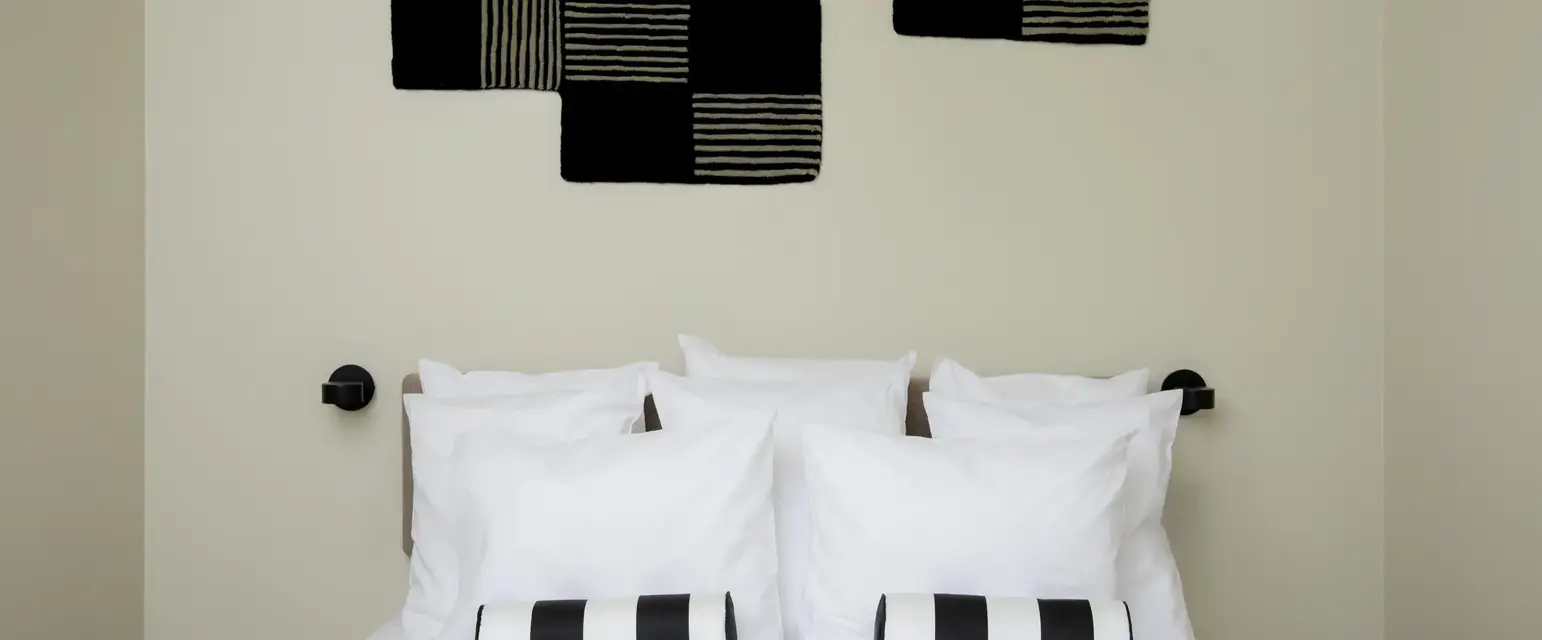 a bed with pillows and a lamp